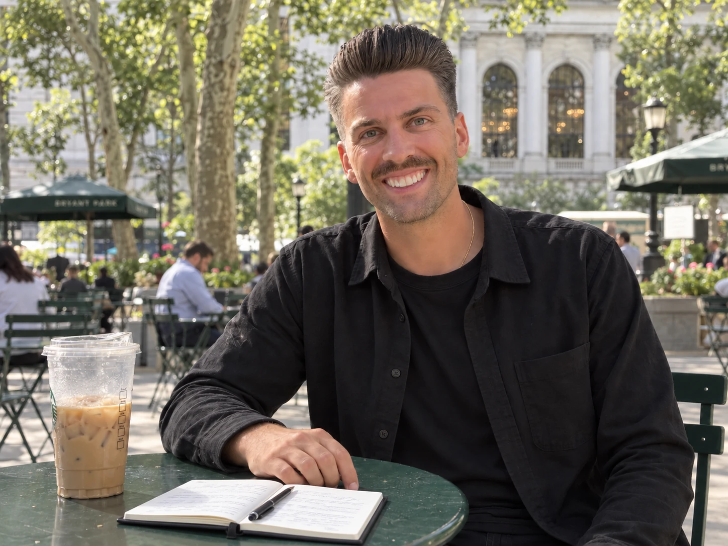 Craig Cowan smiling at a park café table, wearing black
